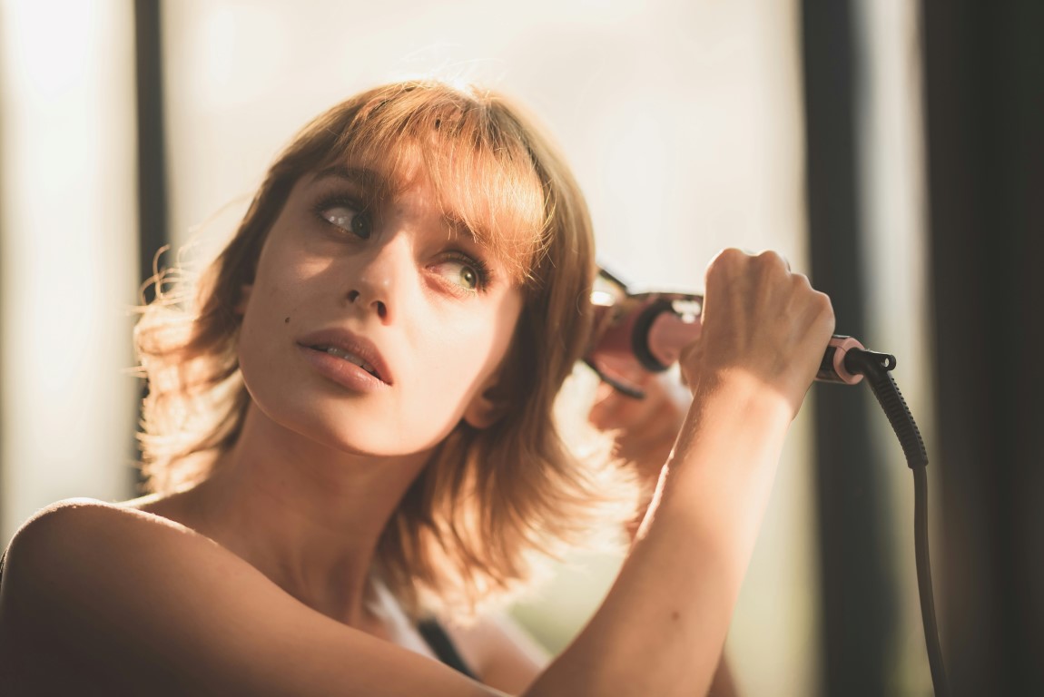 woman showing how to safely straighten hair with straightener
