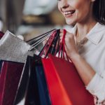 woman smiling and happy about her outlet mall shopping deals