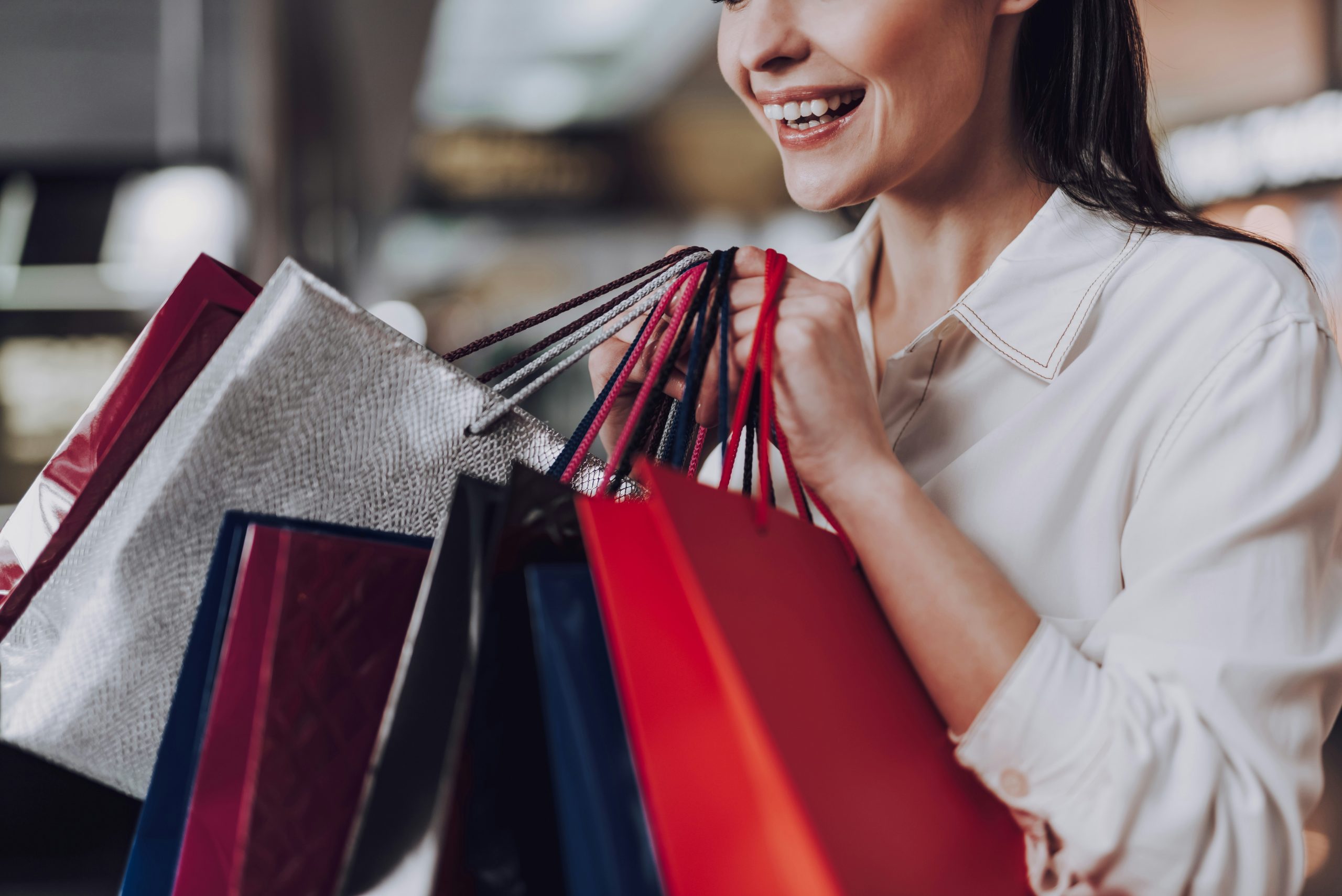 woman smiling and happy about her outlet mall shopping deals