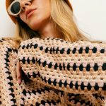 woman sporting a crochet top and sunglasses as a 2026 fashion trend